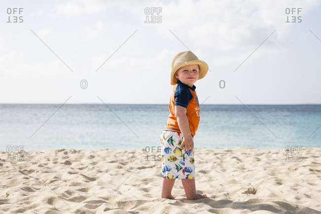 Toddler Boy Wearing Straw Hat in front of Caribbean Ocean on Vacation