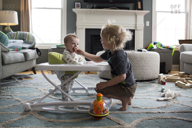 Baby Brother Standing in Walker Eats out of Big Brother's Hand