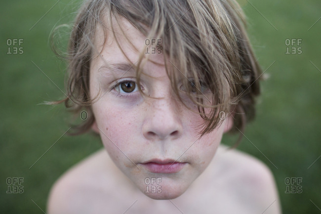 Close Up of Young Boy With Long Hair, Brown Eyes, and Messy Face