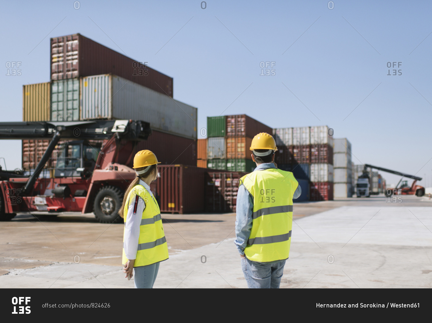 Workers in front of cargo containers on industrial site