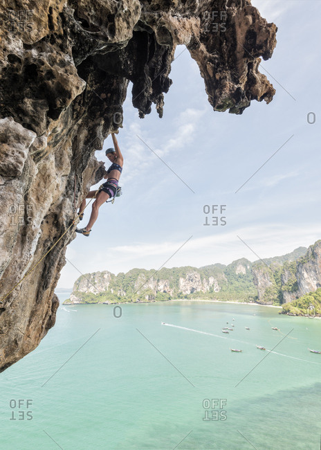 Thailand- Krabi- Thaiwand wall- woman climbing in rock wall above the sea
