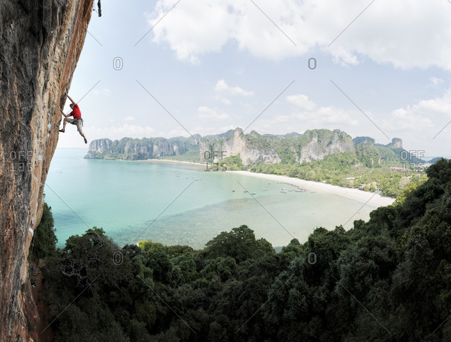 Thailand- Krabi- Thaiwand wall- man climbing in rock wall above the sea