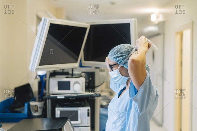 Female doctor tying surgical mask- preparing for surgery