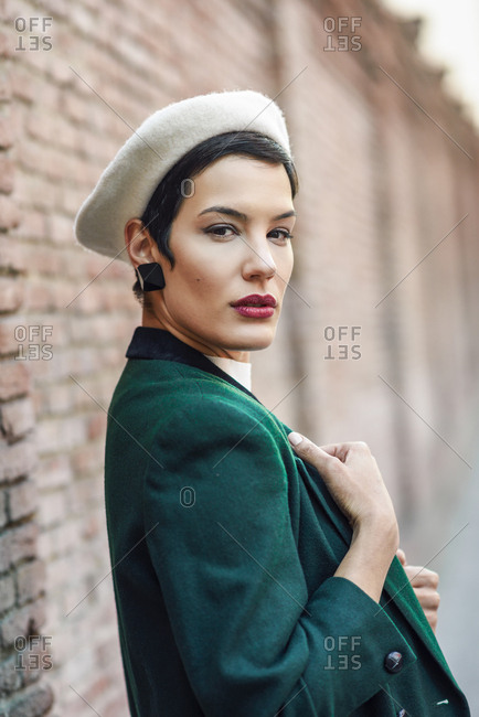Portrait of fashionable young woman at a brick wall