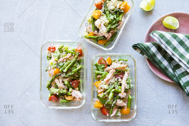 Meal prep of glass container filled with salad asparagus and quinoa
