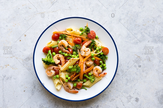 Pasta penne primavera vegetables with shrimp on a plate