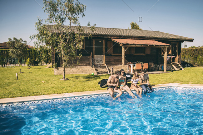 Young friends having drinks in pool