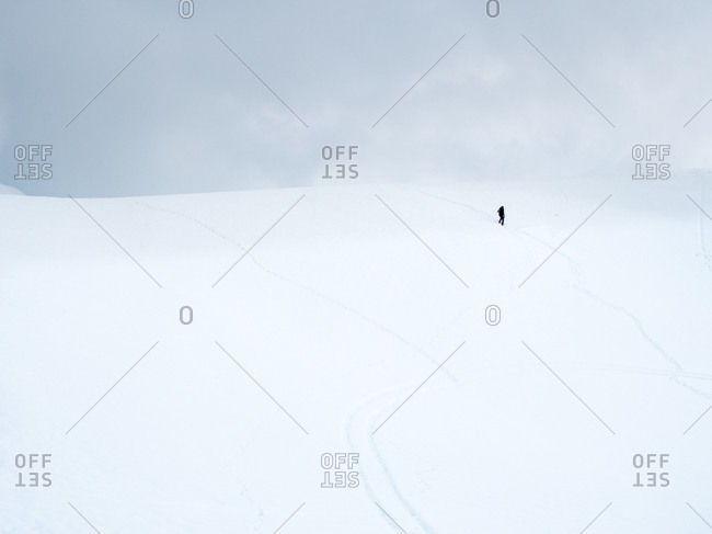 Person standing in the distance on a cold snowy hill