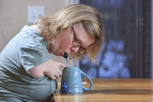 Woman with TAR Syndrome painting her nails at home.