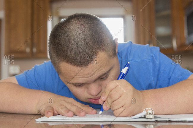Teen with Down Syndrome studying.