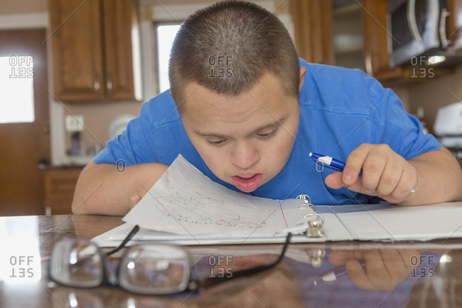 Teen with Down Syndrome studying.