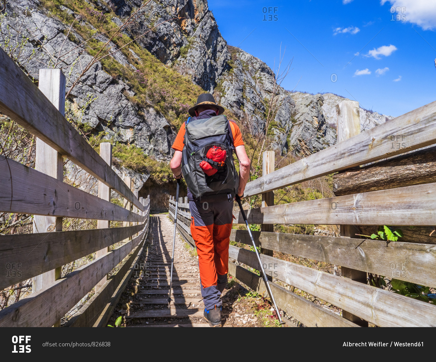 Spain- Asturia- Cantabrian Mountains- senior man on a hiking trip crossing a bridge