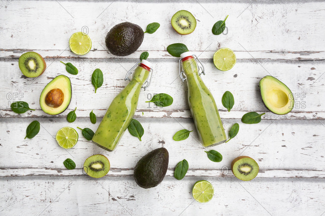 Two bottles of green smoothie with avocado- spinach- kiwi and lime