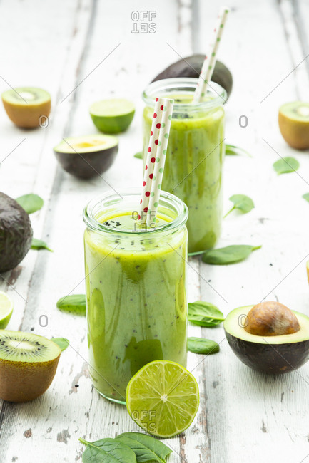 Two glasses of green smoothie with avocado- spinach- kiwi and lime