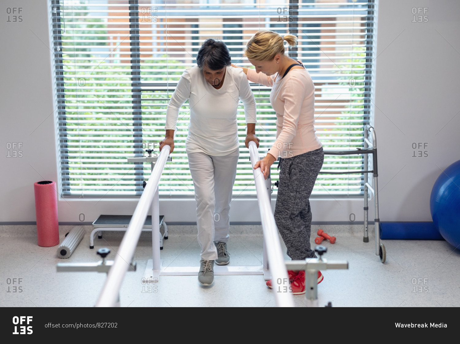 Front view of Caucasian female physiotherapist helping mixed-race ...