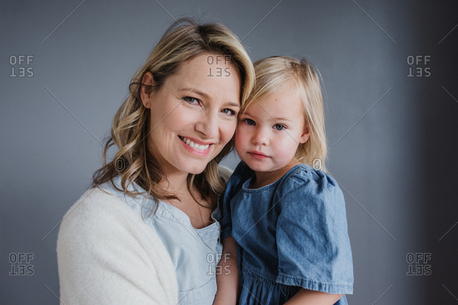 Portrait of a blonde mom and blonde toddler daughter