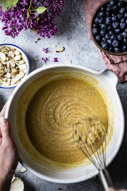 Mixing a cake mixture in a mixing bowl surrounded by ingredients