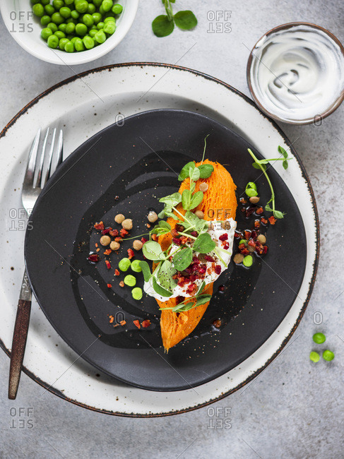 Whole baked sweet potato with sweet peas, lentils and bacon crumbs