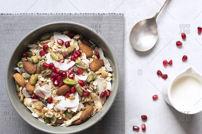Healthy breakfast bowl of dried fruit, nuts, muesli and pomegranate seeds.
