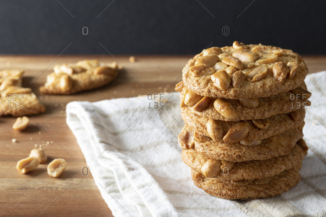 A stack of crisp peanut biscuits with a broken biscuit in the background.