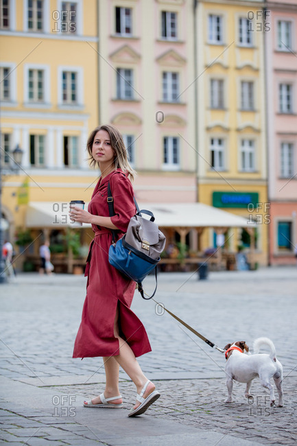 Young Woman Walking A Dog In The City While Drinking Coffee Stock Photo Offset