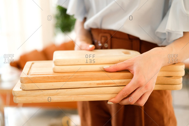 Woman carrying stack of wooden cutting boards