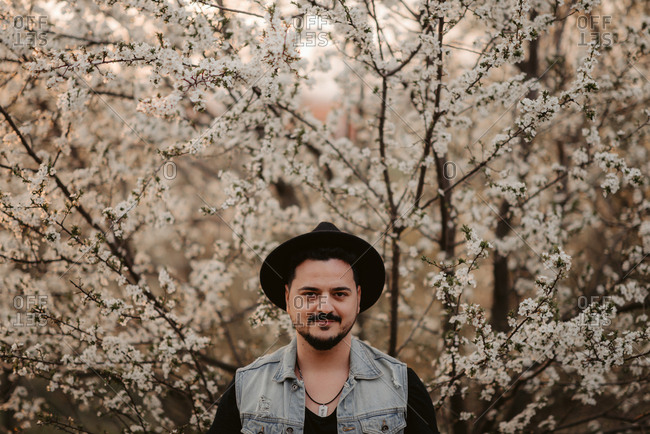Portrait of a man standing in front of cherry blossoms