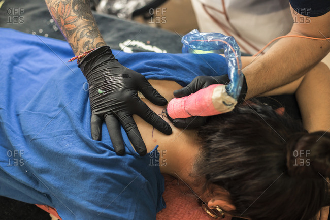 Tatto artist tattooing a woman
