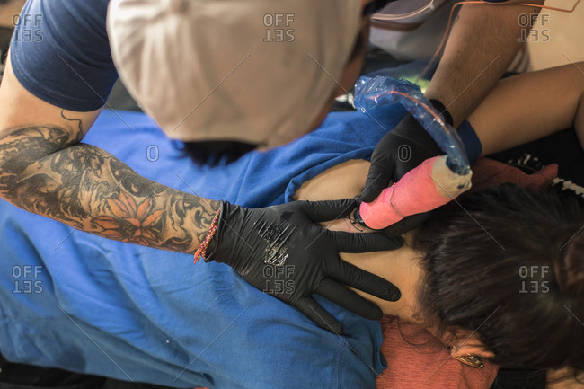 Tatto artist tattooing a woman