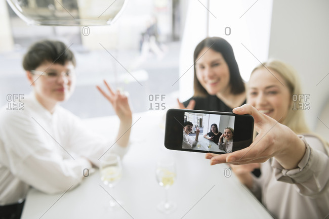 Happy friends taking selfie in a restaurant