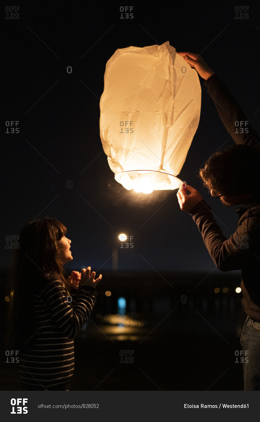 Father and daughter preparing a sky lantern at night