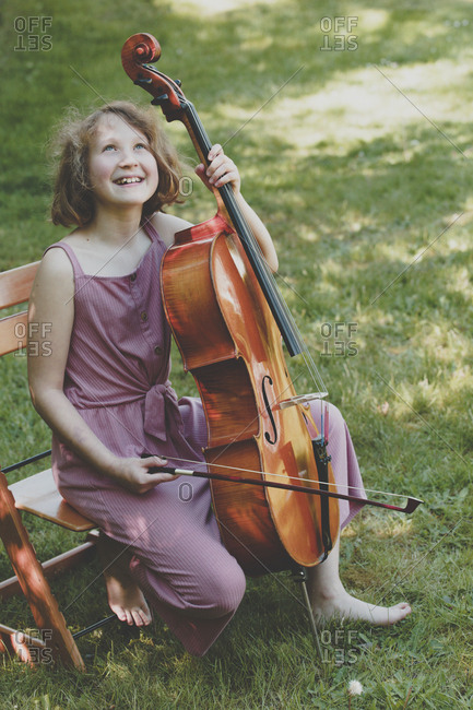 A girl with the cello in garden