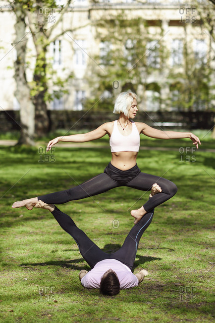 Young couple doing yoga acrobatics in an urban park
