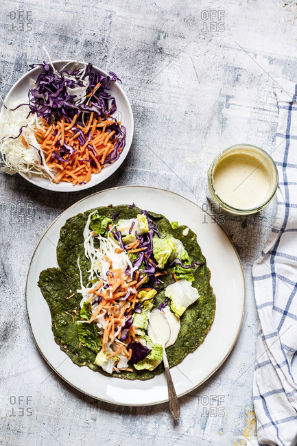 Lettuce wrap with spinach tortillas filled with lettuce- carrots and salad dressing