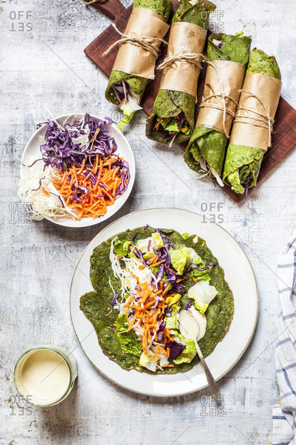 Lettuce wraps with spinach tortillas filled with lettuce- carrots and salad dressing