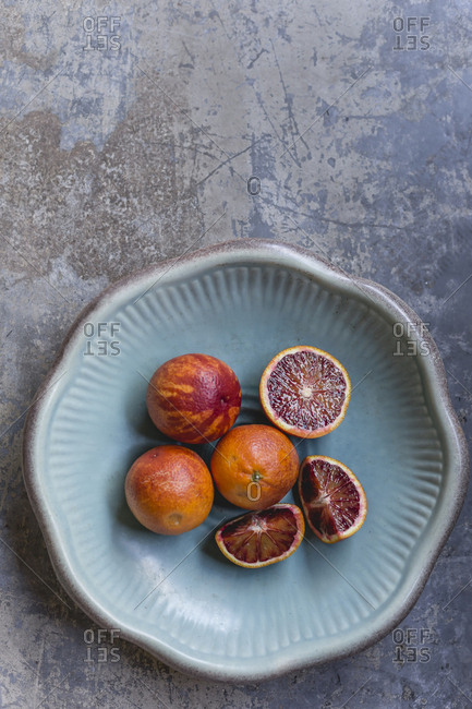 Whole and sliced blood oranges in a bowl