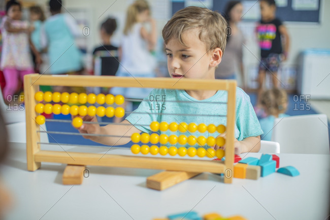 Boy in kindergarten using abacus