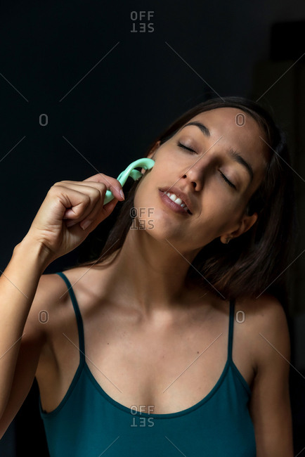 Brunette woman using a facial massager