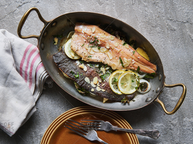 Cooked trout in pan with almonds lemon and parsley