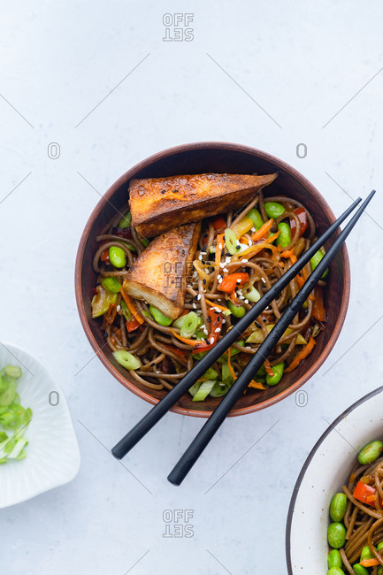 Asian-styled lunch with vegetarian soba noodles with fried vegetables, edamame beans and tofu