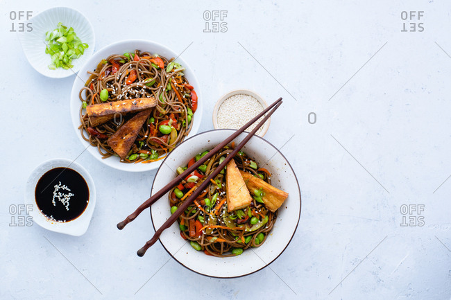 Asian-styled lunch with vegetarian soba noodles with fried vegetables, edamame beans and tofu