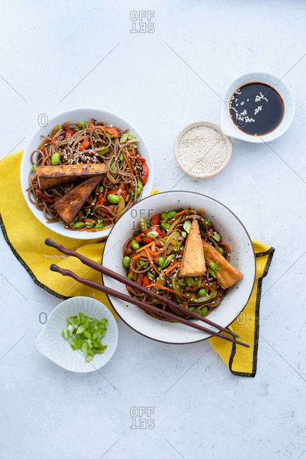 Asian-styled lunch with vegetarian soba noodles with fried vegetables, edamame beans and tofu