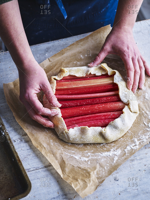 Baker preparing a rhubarb galette by hand