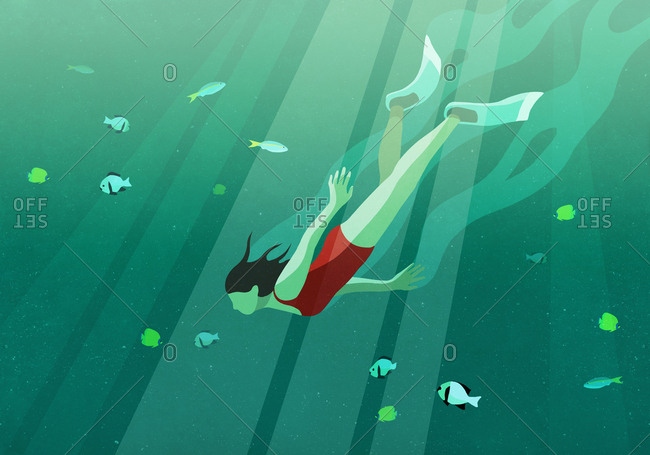 Woman swimming underwater in ocean surrounded by fish