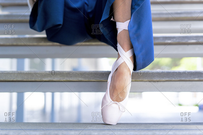 Female dancer with toe shoe sitting on steps