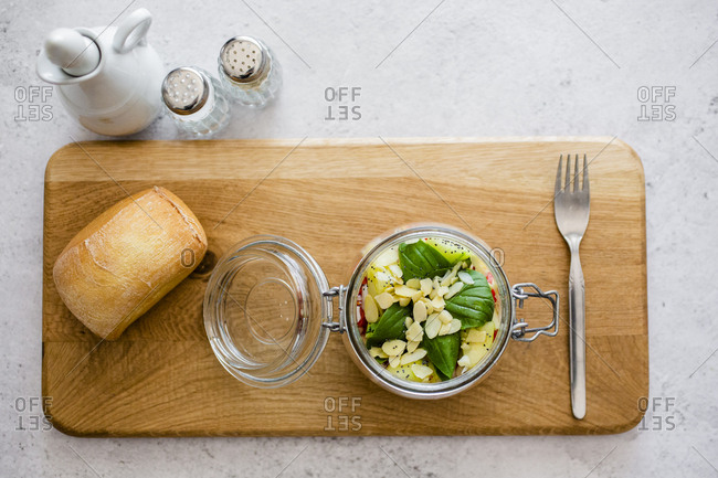 Glass of salad with cucumbers- chickpeas- onion- cherry tomatoes- basil- chia seed and sliced almonds