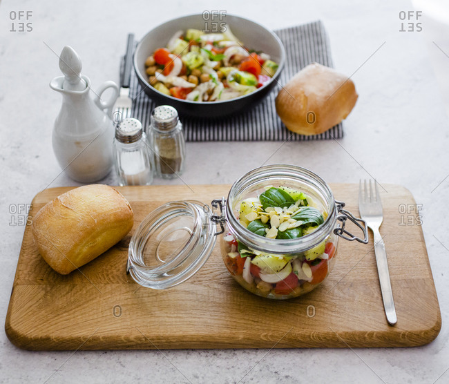 Glass of salad with cucumbers- chickpeas- onion- cherry tomatoes- basil- chia seed and sliced almonds