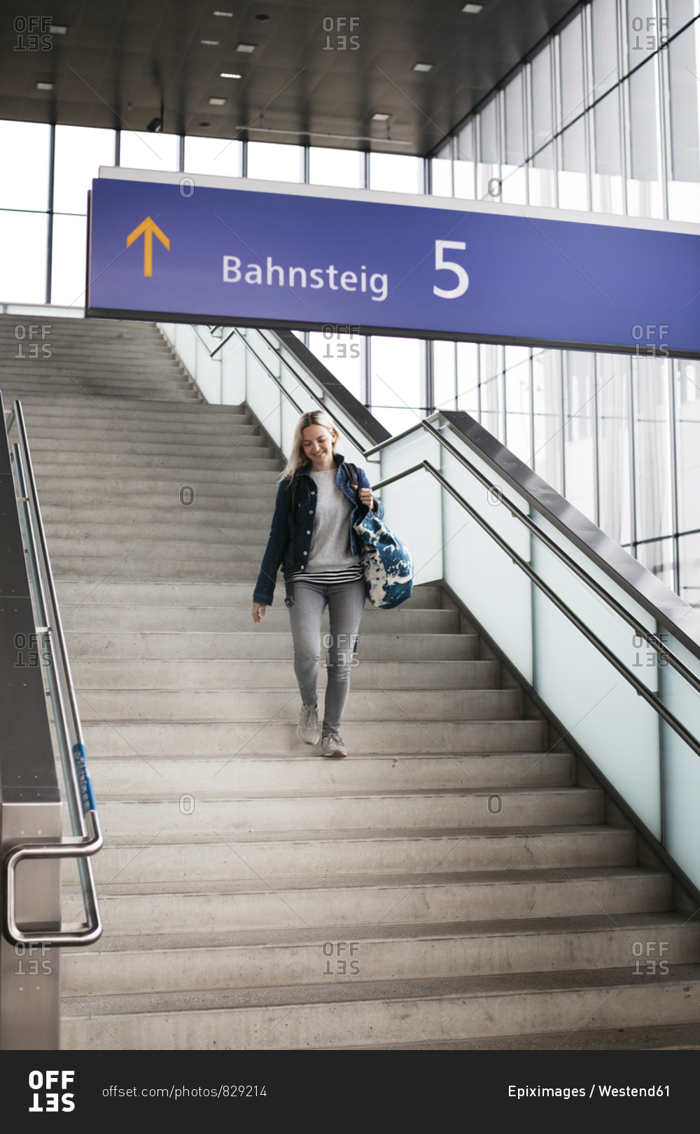 Smiling woman walking down stairs at the station
