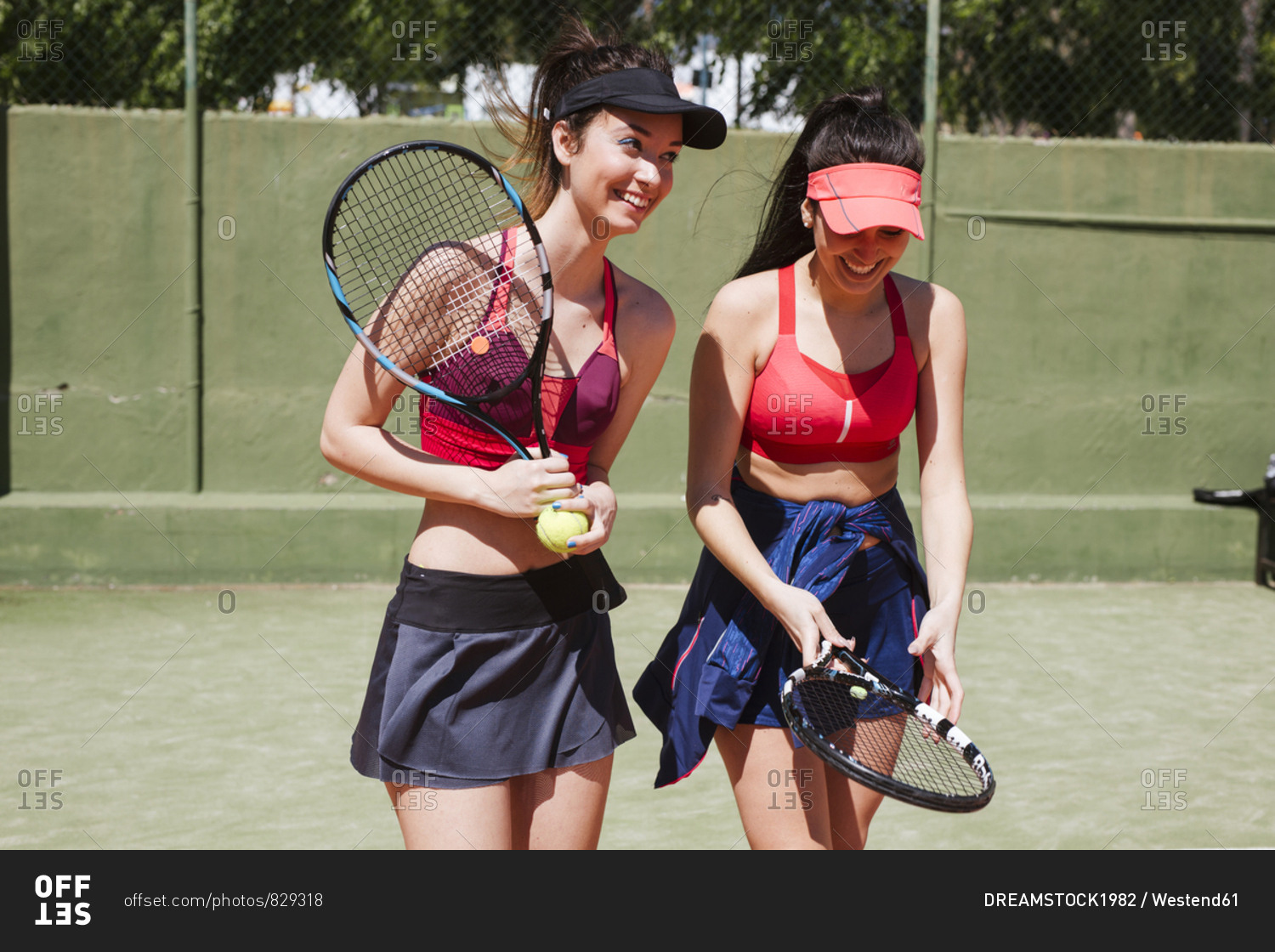Two happy female tennis players on the court