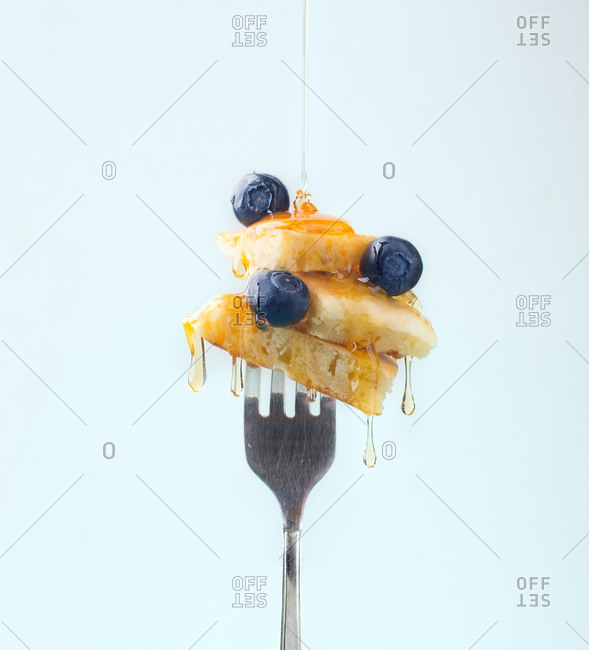 Composition of sweet dessert with strawberry and blueberries flavored by honey on white background
